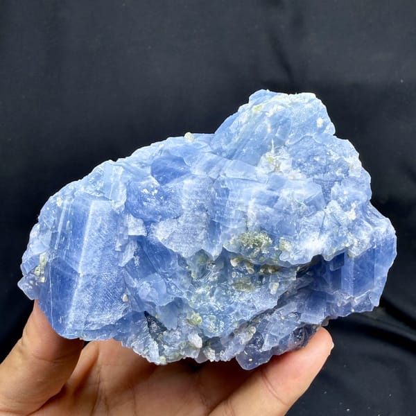 Block of pale blue calcite with peridot grains from Vietnam, close-up of the crystal faces