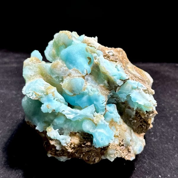 Robin's-egg blue botryoidal aragonite over brown rock from Yunnan, China, held in hand