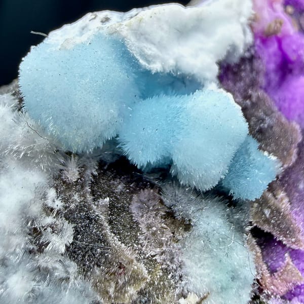 Magenta, blue and white aragonite on dark rock wedge from Yunnan, China, top view