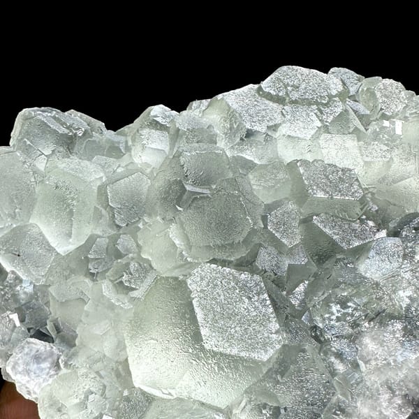 Mound of pale green stepped fluorite cubes from Fujian, China, close-up of the crystal faces