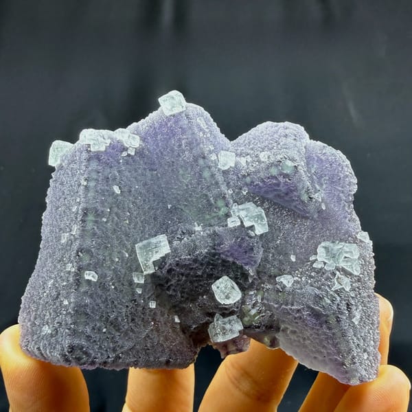Sparkling stepped purple fluorite block from Fujian, China, held in hand