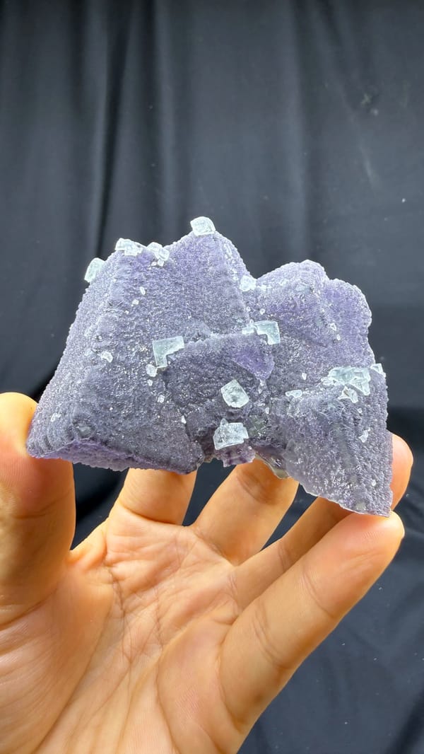 Sparkling stepped purple fluorite block from Fujian, China, close-up of the crystal faces