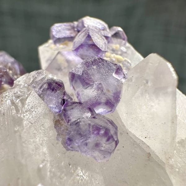 Clear quartz crystal with chain of purple fluorite cubes from Yaogangxian Mine, Hunan, China, close-up of the crystal faces