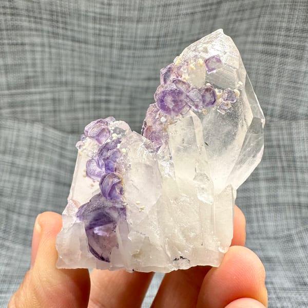 Clear quartz crystal with chain of purple fluorite cubes from Yaogangxian Mine, Hunan, China, side view