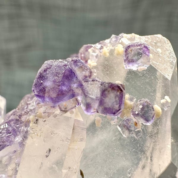 Clear quartz crystal with chain of purple fluorite cubes from Yaogangxian Mine, Hunan, China, close-up of terminations