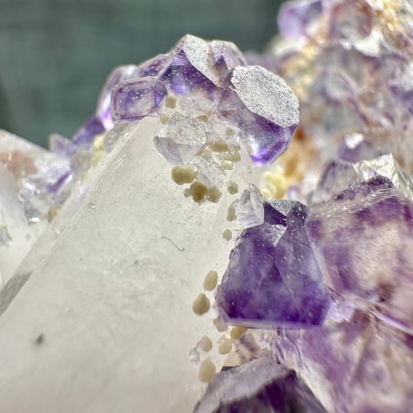 Clear quartz crystal with chain of purple fluorite cubes from Yaogangxian Mine, Hunan, China, oblique view