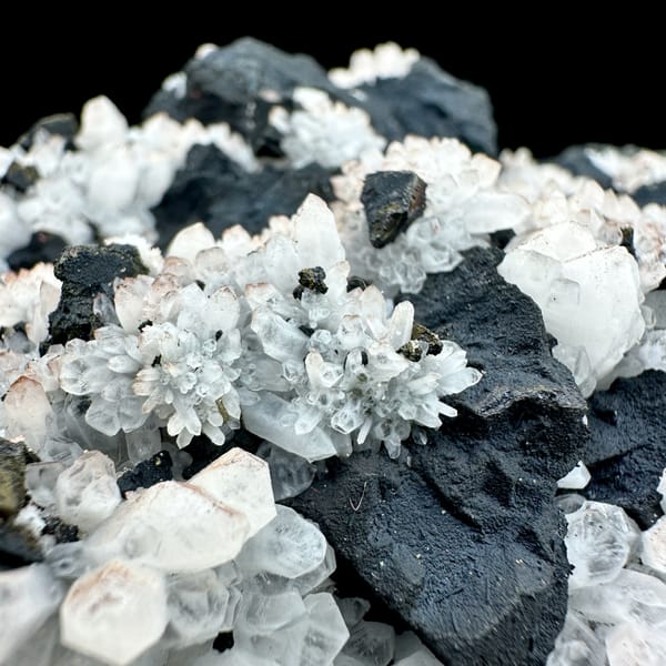 Pale red quartz crystals on black matrix with chalcopyrite from Jiangxi, China, top view