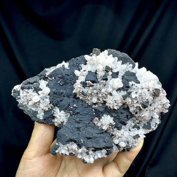 Pale red quartz crystals on black matrix with chalcopyrite from Jiangxi, China, detail of the matrix contact