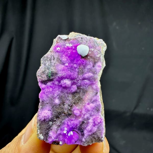 Vivid violet aragonite with blue aragonite ball from Yunnan, China, held in hand