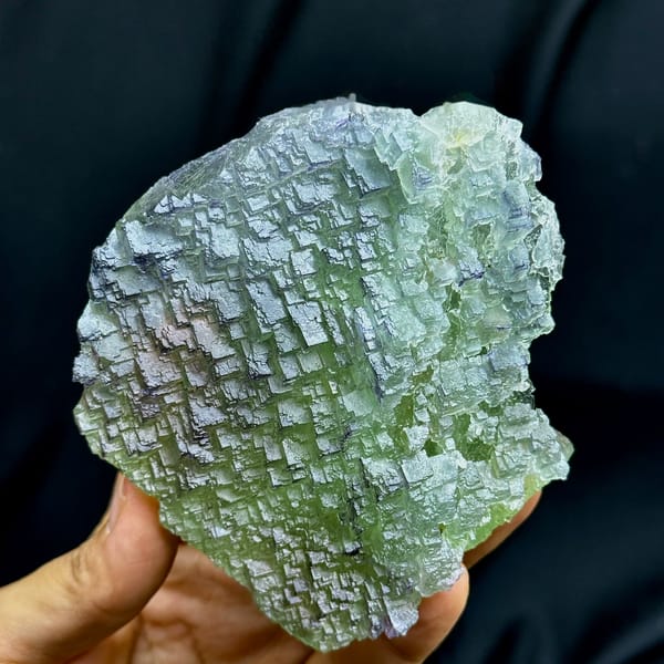 Purple-rimmed green stepped fluorite plate from Jiangxi, China, held in hand