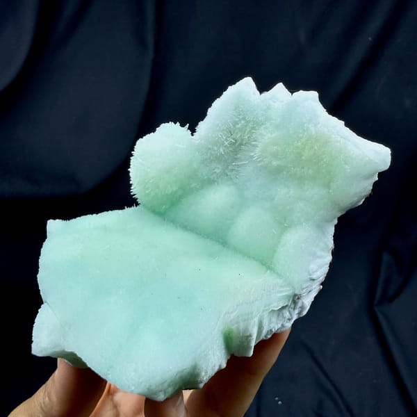 Soft aqua-green acicular aragonite mound from Yunnan, China, held in hand