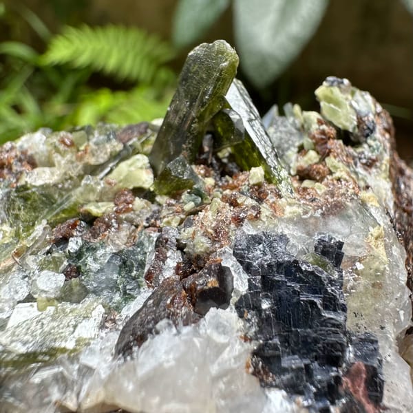 Green diopside crystals with garnet and galena from Inner Mongolia, China, close-up of the crystal faces
