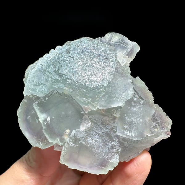 Window-faced stepped fluorite cluster with purple zoning from Guangxi, China, held in hand