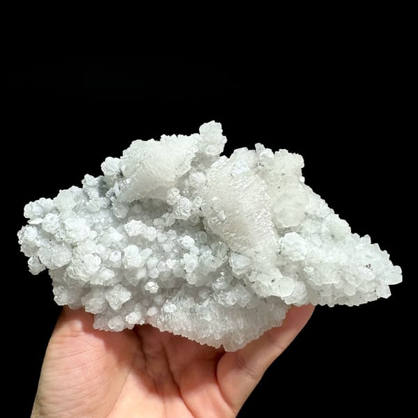 Floater of stepped white calcite with quartz from Guangdong, China, held in hand