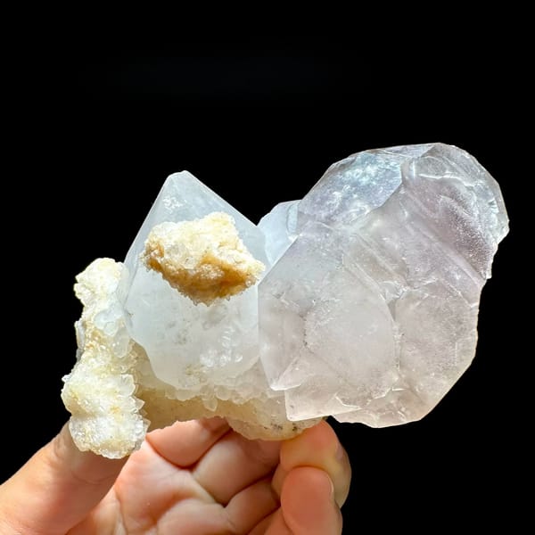 Pale purple and white cathedral quartz group from Brazil, held in hand
