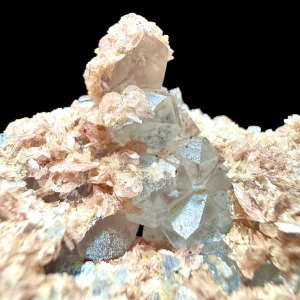 Pale blue fluorite cubes with pink rhodochrosite crusts from Guangxi, China, close-up of the crystal faces
