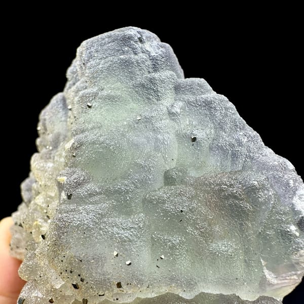 Frosted purple-green fluorite balls dusted with pyrite from Jiangxi, China, close-up of the crystal faces