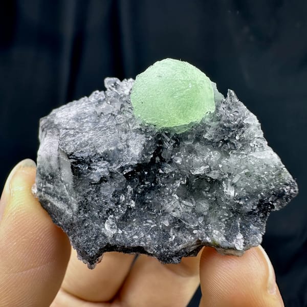 Pale green prehnite ball on dark quartz druse from Sichuan, China, second angle