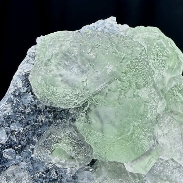 Pale green fluorite cubes in lavender quartz-druse pocket from Fujian, China, close-up of the crystal faces