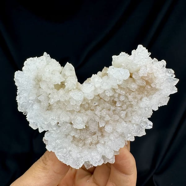 Heart-shaped hollow calcite cluster from Yunnan, China, held in hand