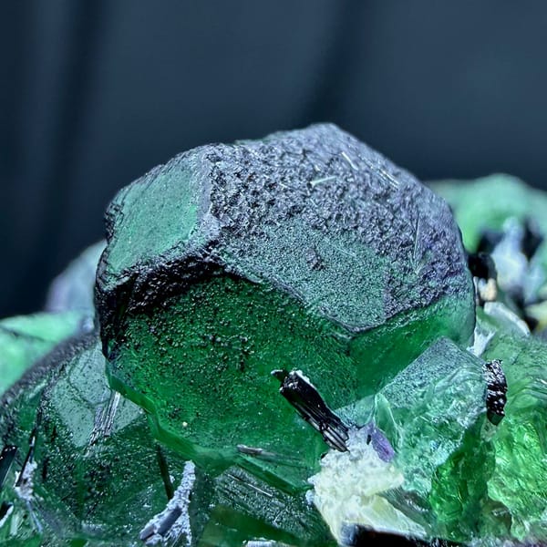 Emerald-green garden fluorite cubes with black tourmaline from Namibia, close-up of the crystal faces