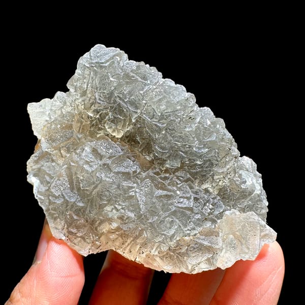 Grey-green fluorite mass sprinkled with pyrite from Xianghualing, Hunan, China, close-up of the crystal faces