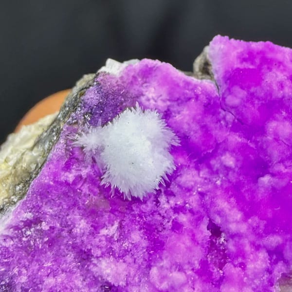 Vivid magenta aragonite with white aragonite tuft from Yunnan, China, close-up of the crystal faces