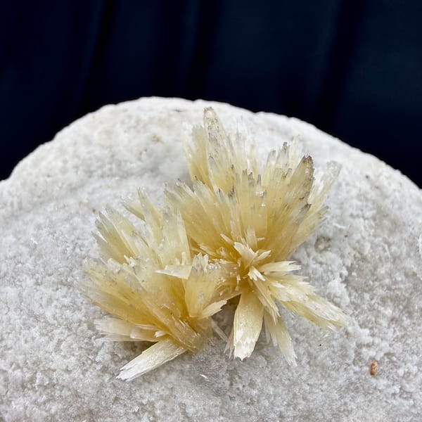 Golden radiating calcite spray on white calcite ball from Yunnan, China, close-up of the crystal faces