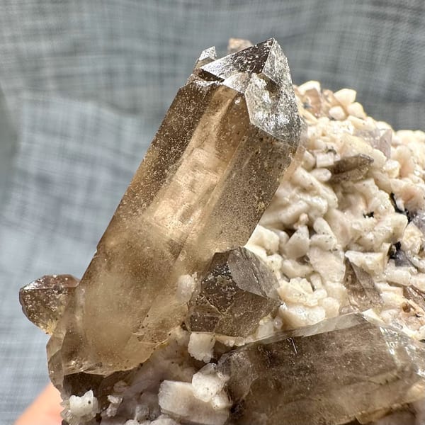 Smoky quartz points on cream feldspar from Yunxiao, Fujian, China, close-up of the crystal faces