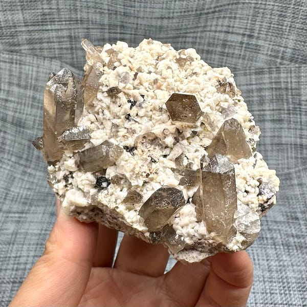 Smoky quartz points on cream feldspar from Yunxiao, Fujian, China, side view