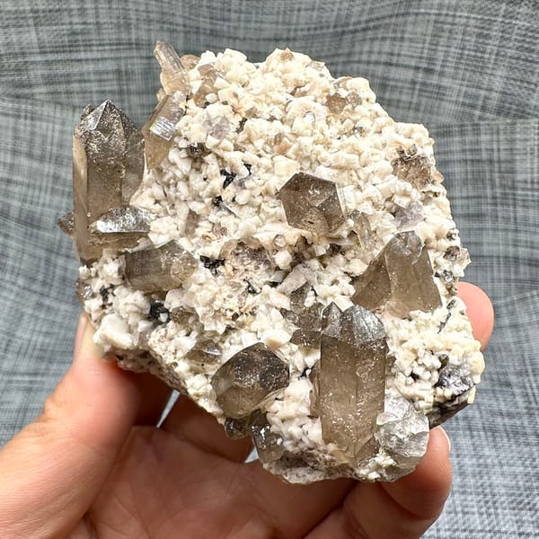 Smoky quartz points on cream feldspar from Yunxiao, Fujian, China, close-up of terminations