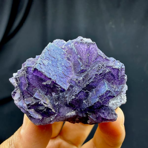 Iridescent purple fluorite with rainbow sheen from Inner Mongolia, China, held in hand
