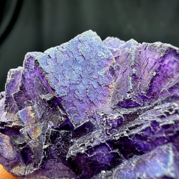 Iridescent purple fluorite with rainbow sheen from Inner Mongolia, China, close-up of the crystal faces