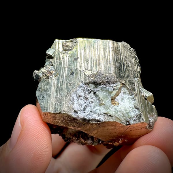 Striated pyrite cube floater with mirror faces from Hunan, China, close-up of the crystal faces