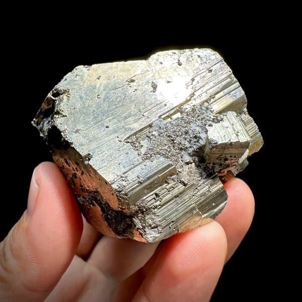 Heavy striated pyrite floater with satin gold lustre from Hunan, China, close-up of the crystal faces