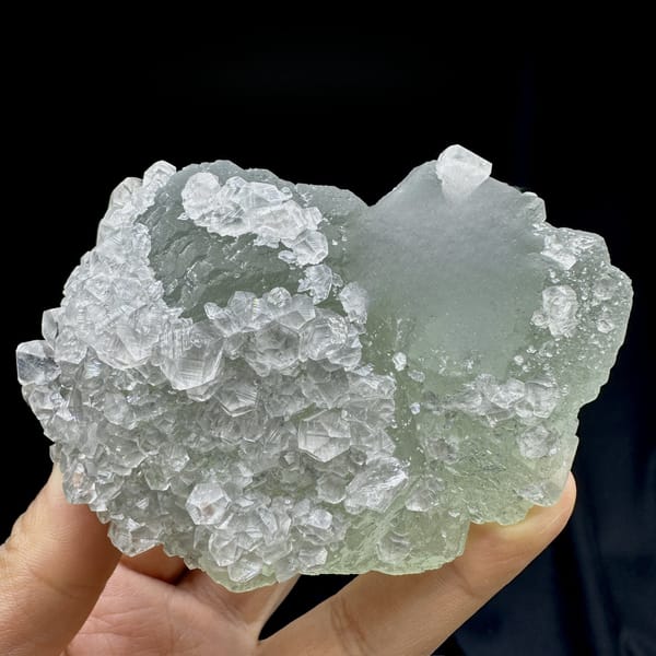 Pale green fluorite balls under white calcite frosting from Fujian, China, detail of the matrix contact
