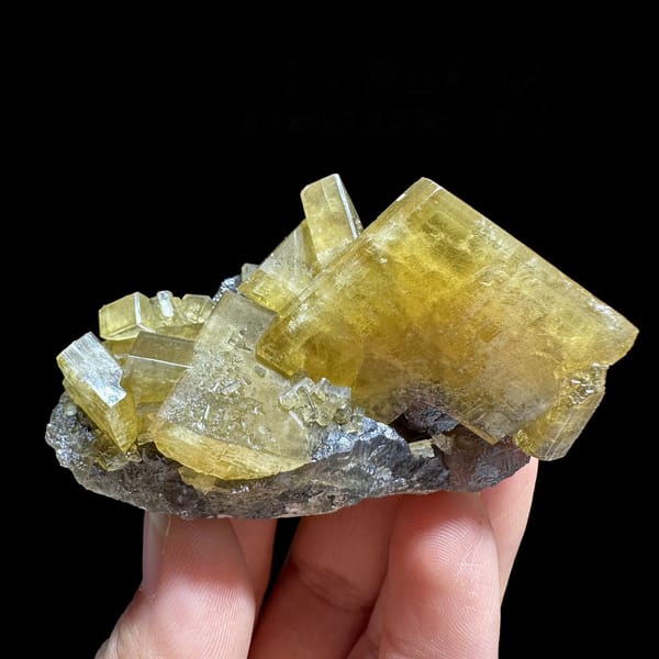 Golden baryte blades on grey base with purple fluorite from Jiangxi, China, detail of the matrix contact