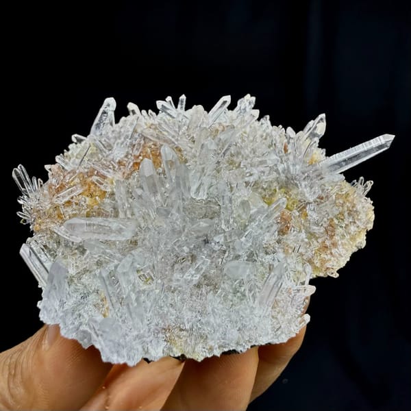 Sunburst of clear quartz needles from Guangdong, China, held in hand