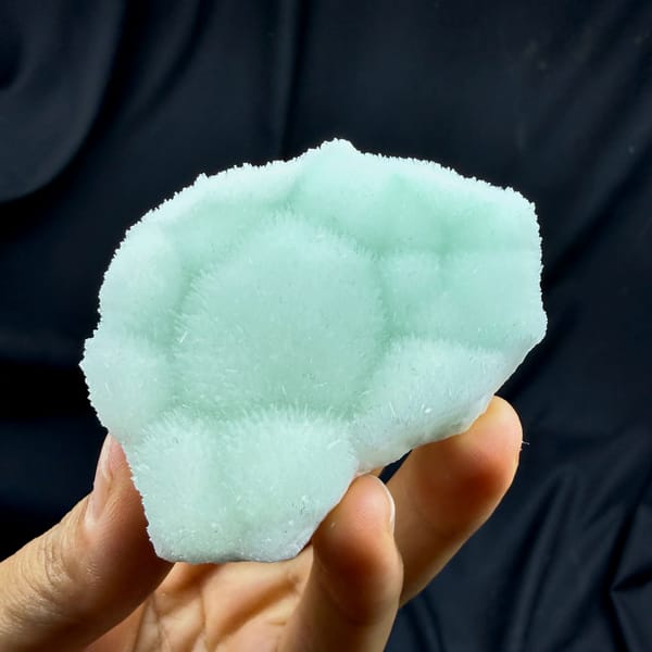 Soft aqua-green aragonite plate with radiating centre from Yunnan, China, close-up of the crystal faces