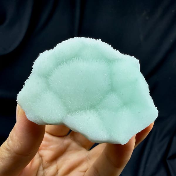 Soft aqua-green aragonite plate with radiating centre from Yunnan, China, reverse side