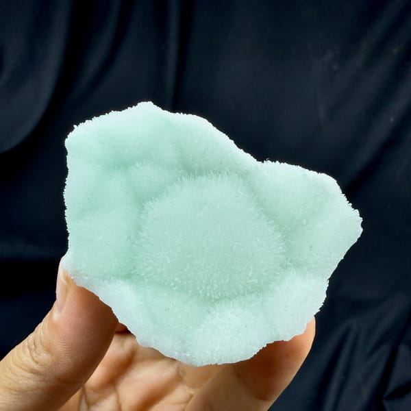 Soft aqua-green aragonite plate with radiating centre from Yunnan, China, detail of the matrix contact