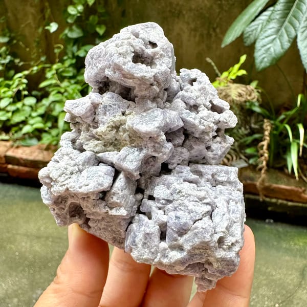 Purple spinel in marble, from Vietnam, front view in daylight, held in hand