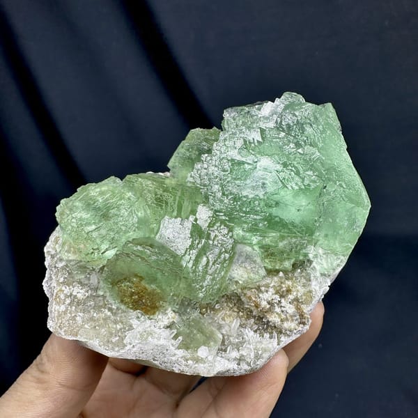 Glassy green fluorite cubes on white quartz druse from Fujian, China, detail of the matrix contact