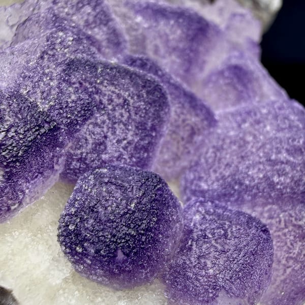 Frosted lavender fluorite cubes beside white quartz druse from Guizhou, China, close-up of the crystal faces