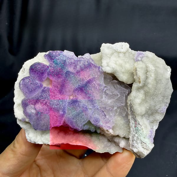 Frosted lavender fluorite cubes beside white quartz druse from Guizhou, China, detail of the matrix contact