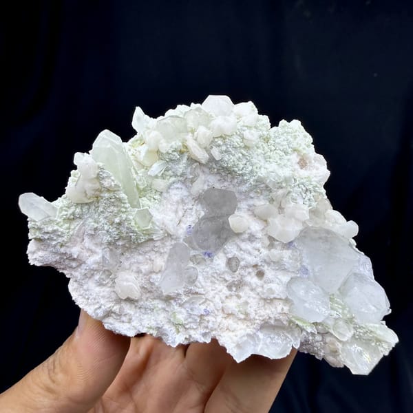 Quartz and calcite with mica, from Hunan, China, front view in daylight, held in hand