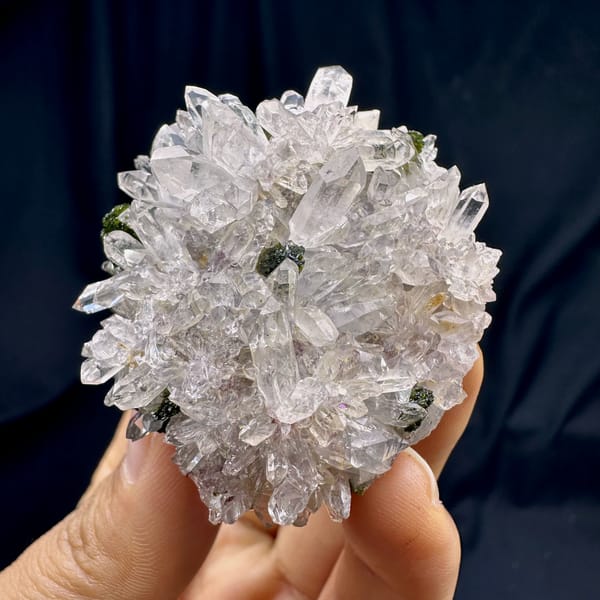 Rounded cluster of sparkling clear quartz with epidote from Sichuan, China, top view