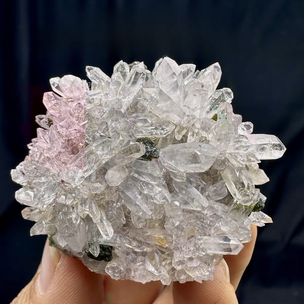 Rounded cluster of sparkling clear quartz with epidote from Sichuan, China, detail of the matrix contact