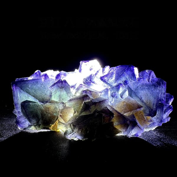 Purple and green octahedral fluorite glowing when, from Zhejiang, China, detail of the matrix contact
