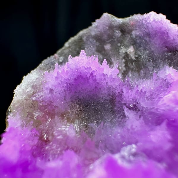 Vivid violet aragonite with clear gypsum blade from Yunnan, China, close-up of the crystal faces